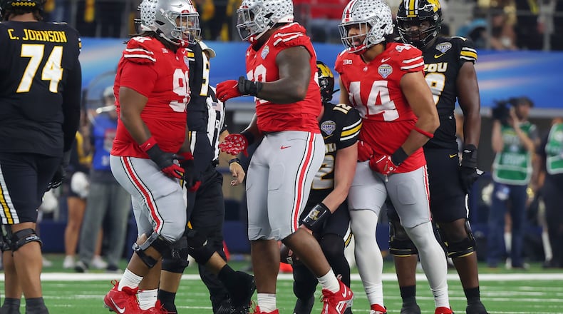 Ohio State defensive tackle Ty Hamilton, middle, celebrates with defensive tackle Tyleik Williams, left, and defensive end JT Tuimoloau (44) after a sack against Missouri during the first half of the Cotton Bowl NCAA college football game Friday, Dec. 29, 2023, in Arlington, Texas. (AP Photo/Richard W. Rodriguez)