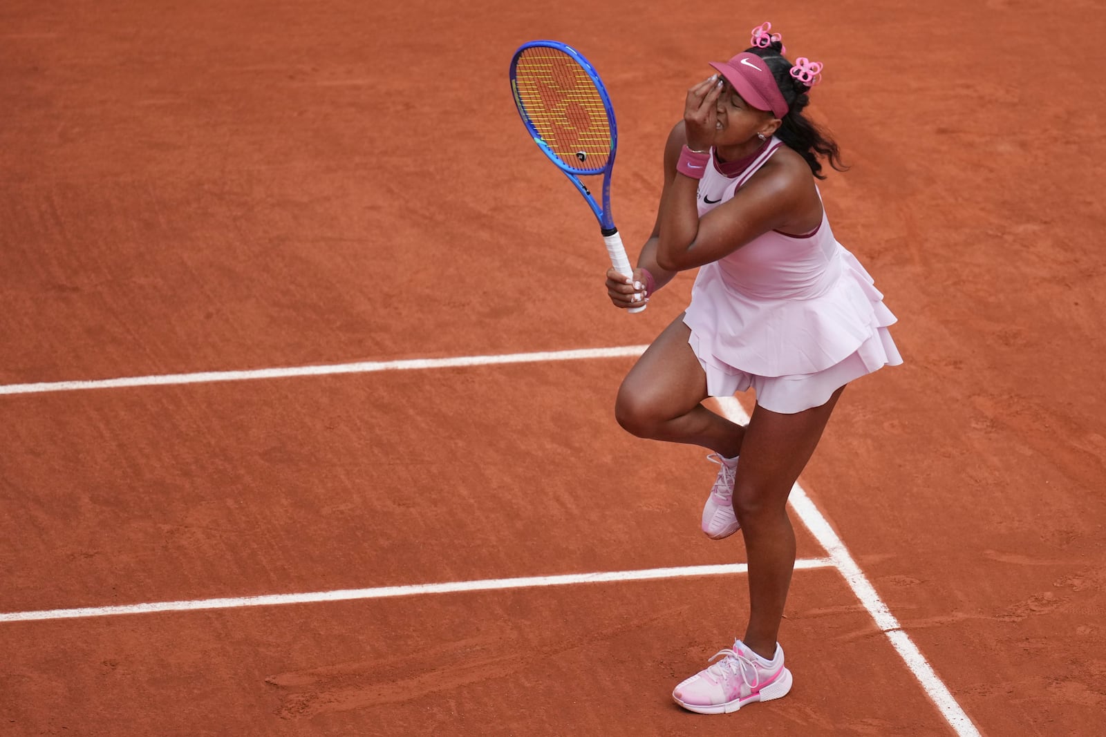 Japan's Naomi Osaka reacts as she plays Spain's Paula Badosa during their first round match of the French Tennis Open, at the Roland-Garros stadium, in Paris, Monday, May 26, 2025. (AP Photo/Christophe Ena)