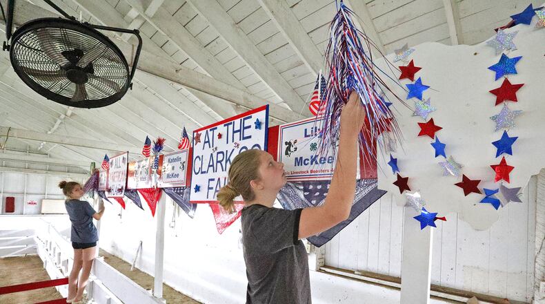 Katelin McKee, right, and her sister, Lily, decorate the pins for their cows Wednesday as they prepare for the opening of the Clark County Fair on Friday. BILL LACKEY/STAFF