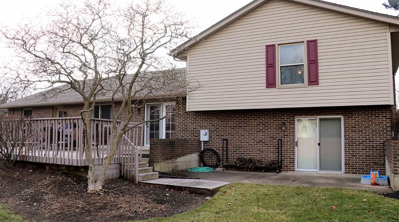 Sliding patio doors open from the lower-level recreation room to a semi-private concrete patio. French doors open from the main-level living room to a wooden deck.