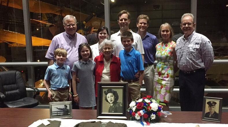 Yolanda ‘Tipi’ Minnehan stands with two of her three children, some of their children and some of her great-grandchildren July 6 at the National Museum of the U.S. Air Force as they admire her uniform artifacts from the Women’s Army Auxiliary Corps, later the Women’s Army Corps. U.S. Air Force Col. Barney Minnehan, whose final active-duty assignment was at Wright-Patterson AFB, is pictured far right. (Skywrighter photo/Amy Rollins)