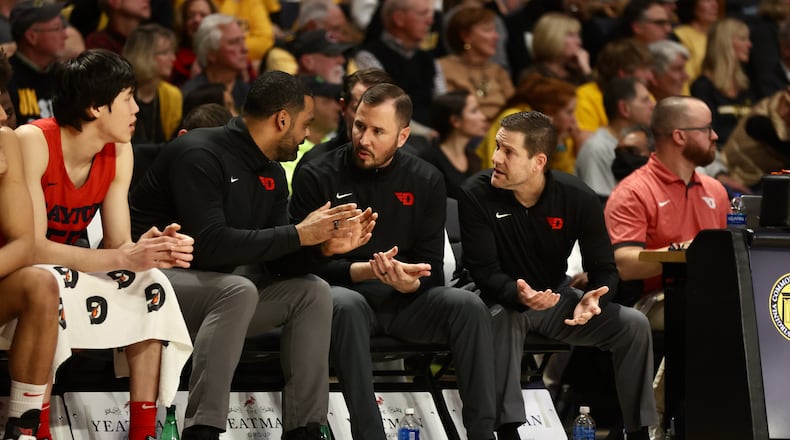 Dayton coaches Ricardo Greer, James Kane and Darren Hertz talk on the bench during a game against Virginia Commonwealth on Tuesday, Feb. 7, 2023, at the Siegel Center in Richmond, Va. David Jablonski/Staff