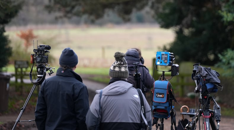 Journsalists wait at the entrance gate of the Sandringham Royal Estate in Sandringham, England, Friday, Feb. 20, 2026 after Andrew Mountbatten-Windsor was arrested and held for hours by British police on suspicion of misconduct in public office related to his links to Jeffrey Epstein.(AP Photo/Alastair Grant)