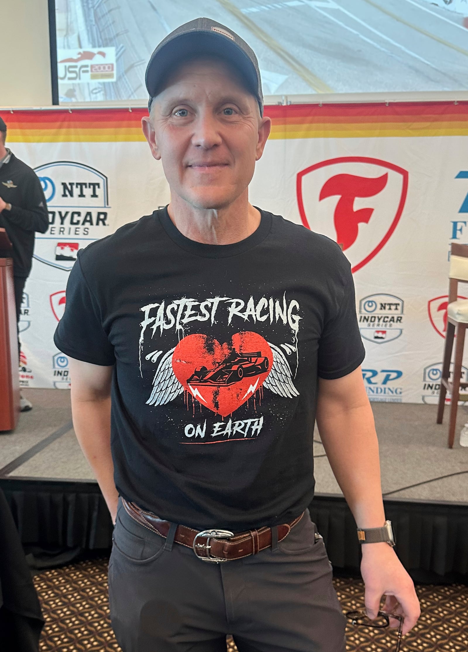 FOX Sports CEO & Executive Producer Eric Shanks poses in a T-shirt he designed to promote the IndyCar auto racing season on March 4, 2025, in St. Petersburg, Fla. (AP Photo/Jenna Fryer)