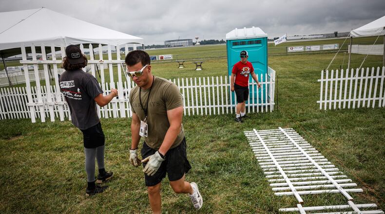 Dayton Air Show workers from left, Connor Buchanan, Nick Hoff and Austin Lackey setup a fence in the private section of the Dayton Air Show in preparation of this weekends show. JIM NOELKER/STAFF