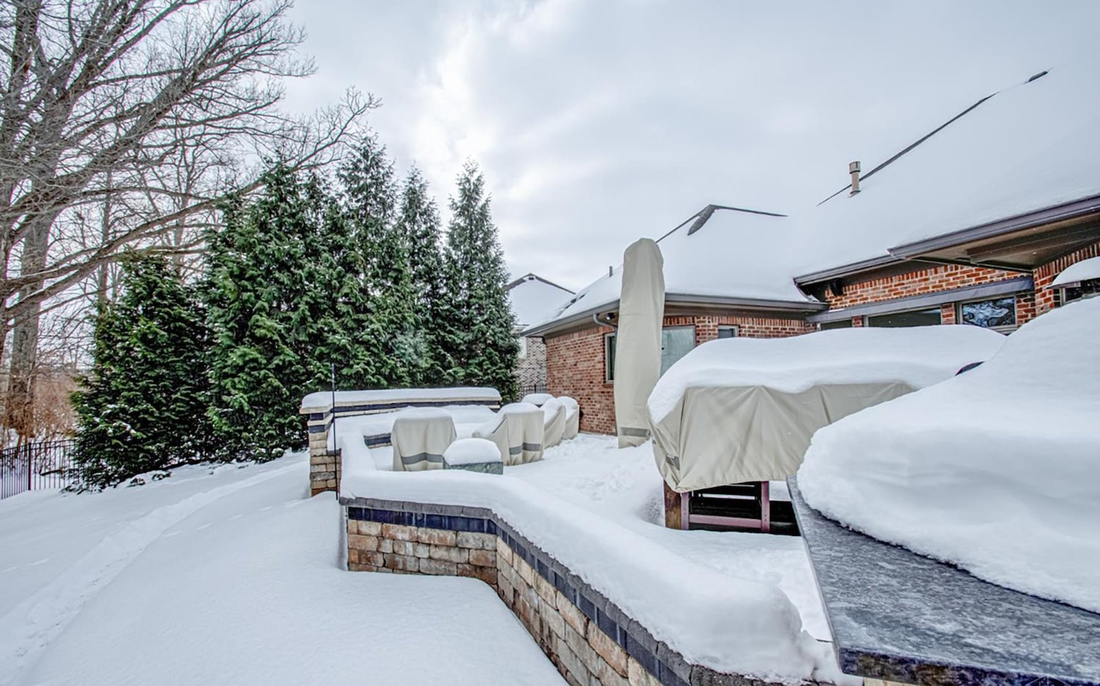 The back yard has been heavily handscaped and features a patio with a surrounding wall, built in grill, firepit with surrounding bench seating and a heated inground pool with water features. CONTRIBUTED