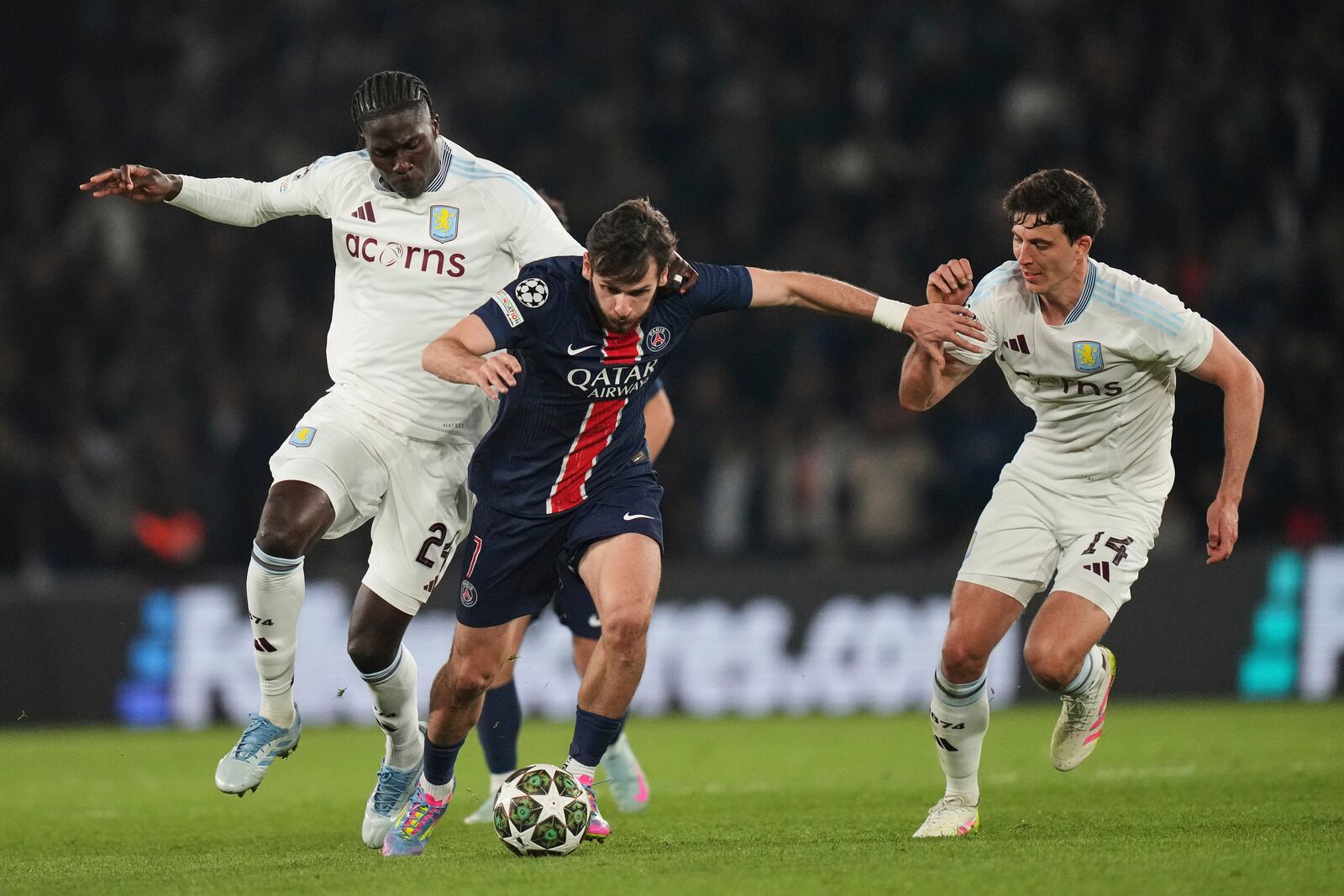 PSG's Khvicha Kvaratskhelia, centre, challenges for the ball with Aston Villa's Amadou Onana, left, and Aston Villa's Pau Torres, right, during the Champions League quarterfinal first leg soccer match between Paris Saint-Germain and Aston Villa at Parc des Princes stadium in Paris, Wednesday, April 9, 2025. (AP Photo/Thibault Camus)