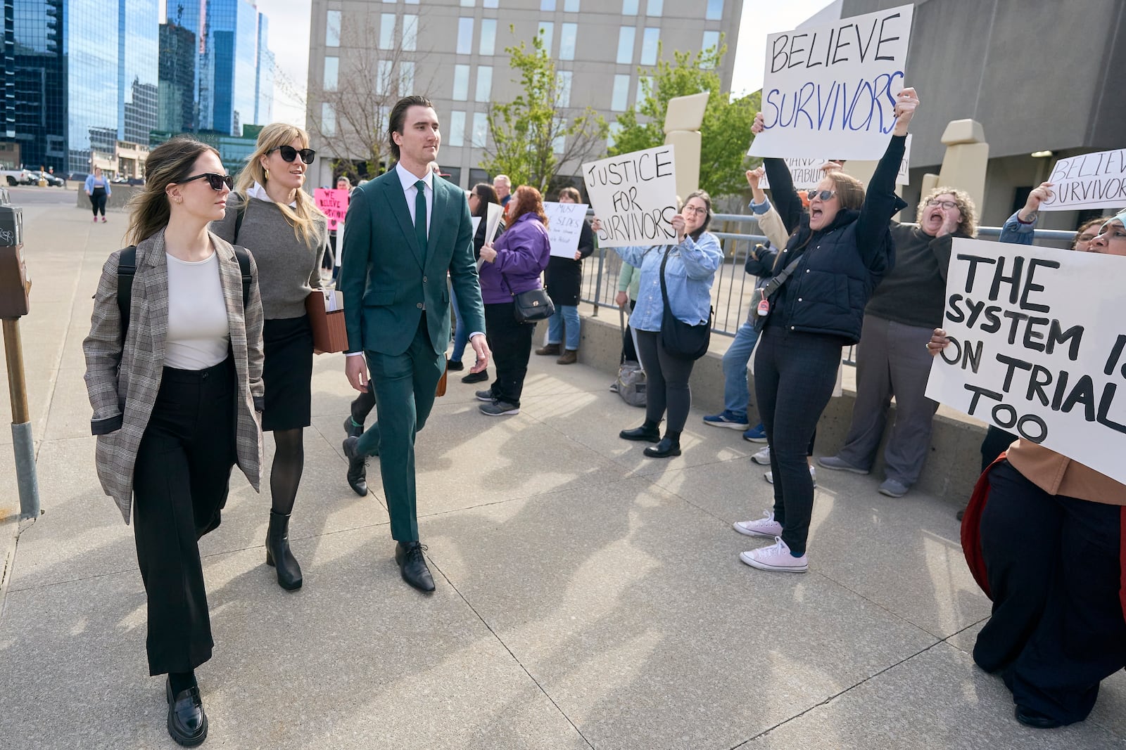 Alex Formenton, one of five hockey players charged with sexual assault, passes protestors as he arrives at the courthouse in London, Ontario, Thursday, May 8, 2025. (Geoff Robins/The Canadian Press via AP)