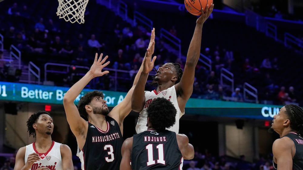 Miami (Ohio) forward Antwone Woolfolk shoots over Massachusetts' Leonardo Bettiol (3) and Jayden Ndjigue (11) in the first half of an NCAA college basketball game in the quarterfinals of the Mid-American Conference tournament, Thursday, March 12, 2026, in Cleveland. (AP Photo/Sue Ogrocki)