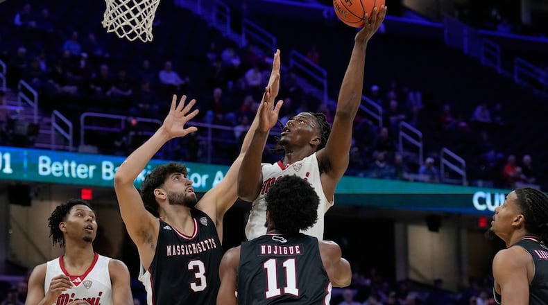 Miami (Ohio) forward Antwone Woolfolk shoots over Massachusetts' Leonardo Bettiol (3) and Jayden Ndjigue (11) in the first half of an NCAA college basketball game in the quarterfinals of the Mid-American Conference tournament, Thursday, March 12, 2026, in Cleveland. (AP Photo/Sue Ogrocki)