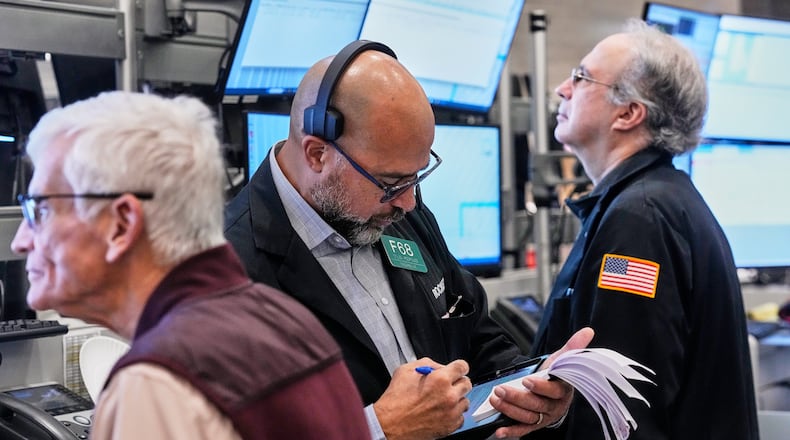 Options trader Steven Rodriguez, center, works on the floor of the New York Stock Exchange, Monday, Oct. 20, 2025. (AP Photo/Richard Drew)