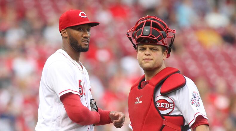 Reds pitcher Amir Garrett and Devin Mesoraco pause after Garrett was hit on the hand by a groundball during a game against Indians on Tuesday, May 23, 2017, at Great American Ball Park in Cincinnati. David Jablonski/Staff