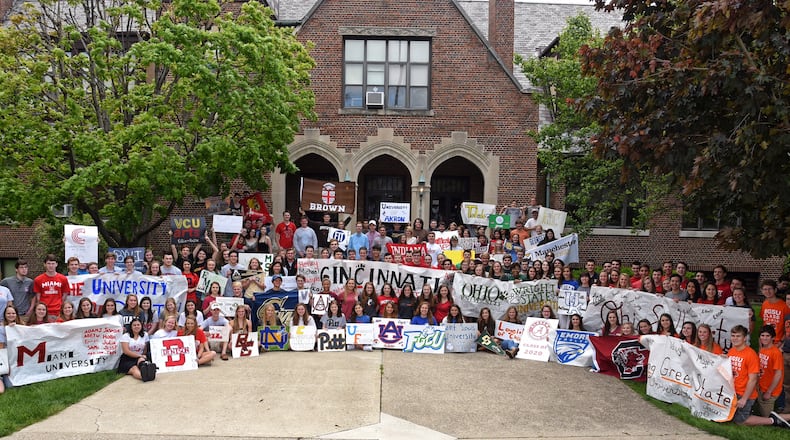 In an annual tradition, the Oakwood High School Class of 2016 gathers in front of the school displaying banners for the colleges they will attend. CONTRIBUTED