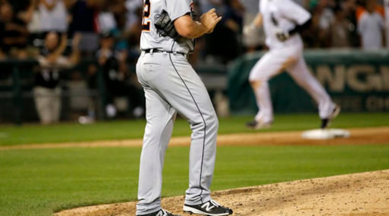 Detroit Tigers starting pitcher Michael Fulmer, left, returns to the mound after giving up a three-run home run to Chicago White Sox's Justin Morneau, right, during the fifth inning of a baseball game Friday, July 22, 2016, in Chicago. Tim Anderson and Jose Abreu also scored on the play. (AP Photo/Charles Rex Arbogast)