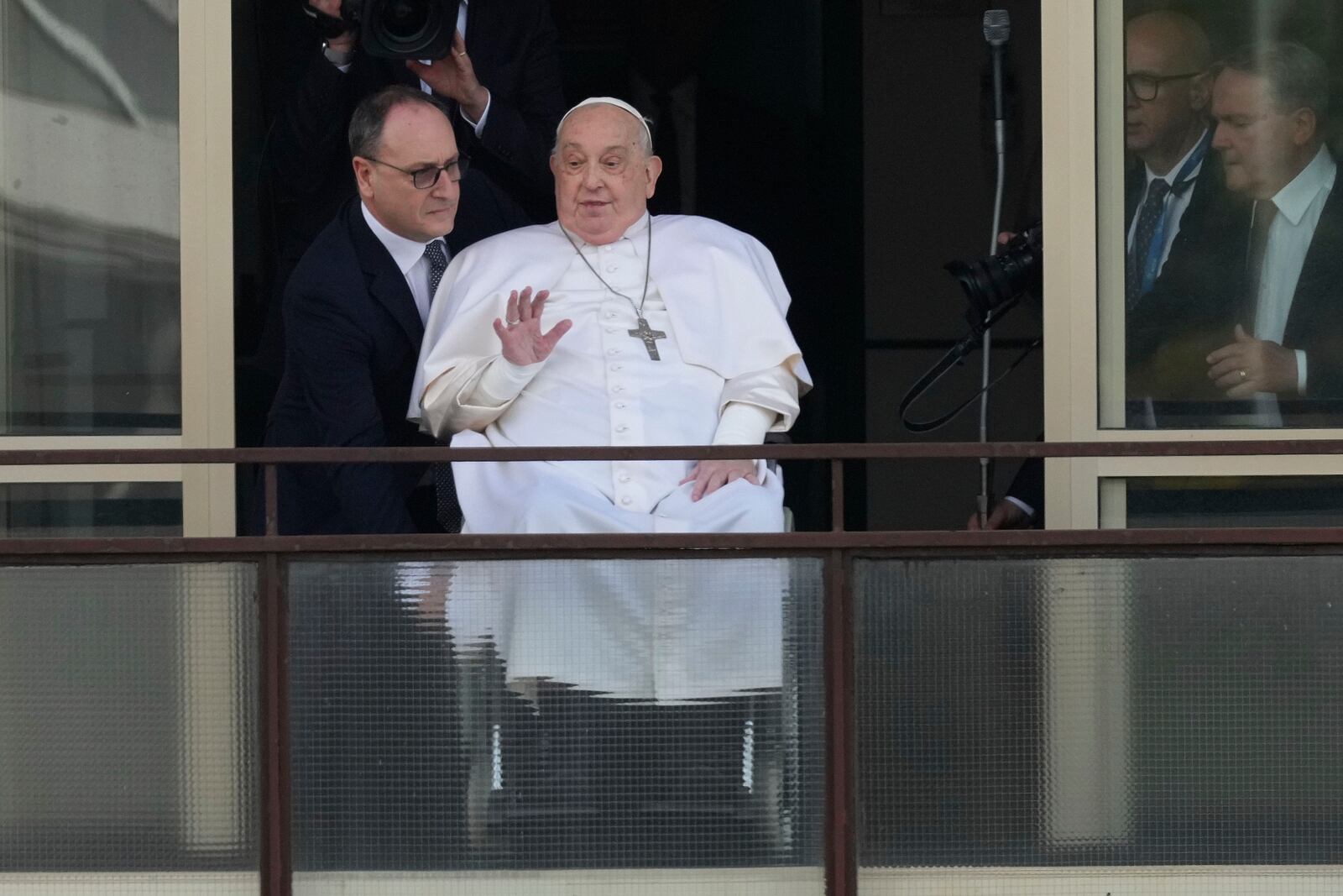 FILE - Pope Francis waves as he appears at a window of the Agostino Gemelli Polyclinic in Rome, Sunday, March 23, 2025, where he has been treated for bronchitis and bilateral pneumonia since Feb. 14. (AP Photo/Andrew Medichini, File)