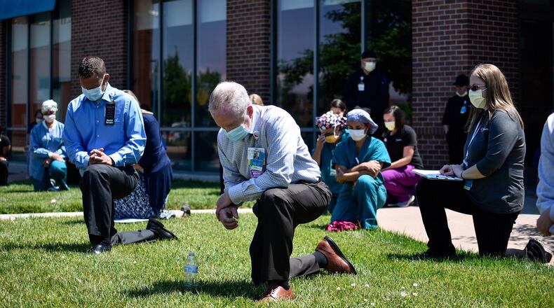 Nearly fifty employees kneeled for eight minutes and 46 seconds for a period of silence to reflect on racial injustice during a Juneteenth event outside of Cincinnati Children’s Liberty Campus Friday, June 19, 2020 in Liberty Township. Cincinnati Children’s employees take a knee in recognition that black lives matter, and in support of their employees, patients, families and communities. NICK GRAHAM / STAFF