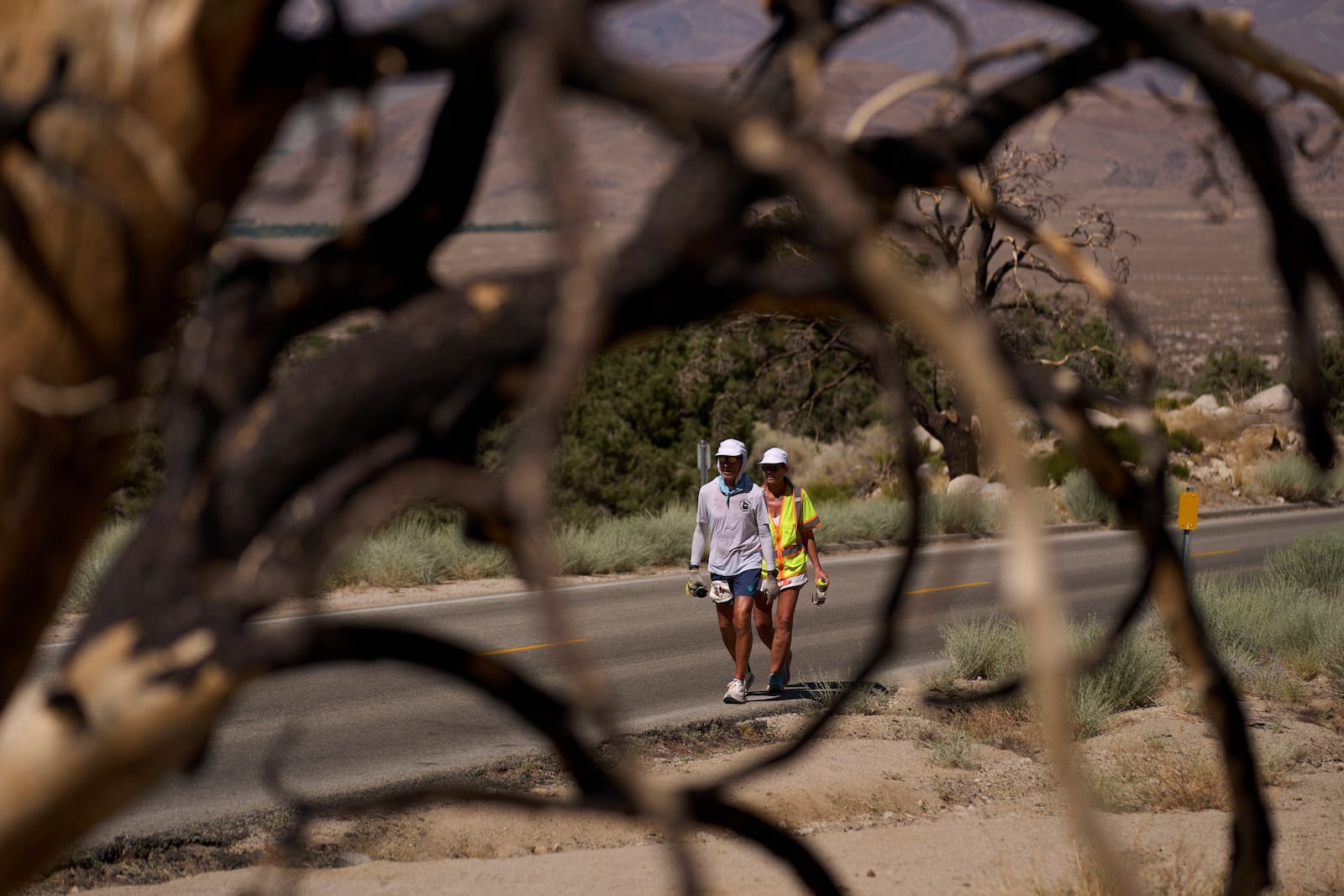 Danny Westergaard, left, competes during the Badwater 135 Ultramarathon beside Jennifer Drain, his cousin and crew lead, Wednesday, July 9, 2025, near Lone Pine, Calif. (AP Photo/John Locher)