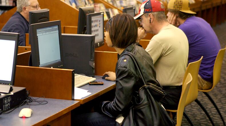 Patrons use the computer stations at the Fairfield Lane Library. GREG LYNCH/STAFF