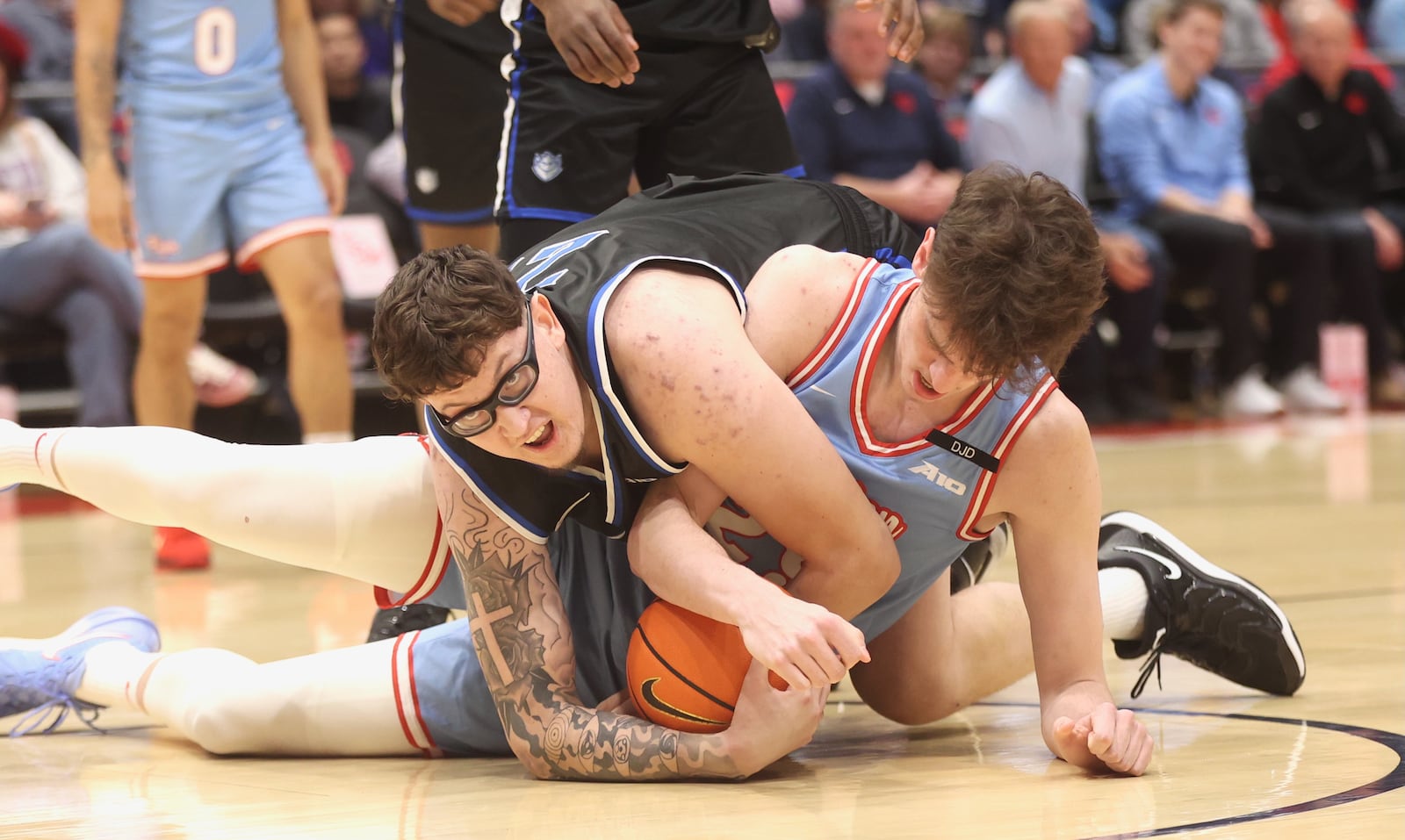 Dayton's Amaël L'Etang, right, and Robbie Avila, of Saint Louis, compete for a loose ball on Tuesday, March 4, 2025, at UD Arena. David Jablonski/Staff