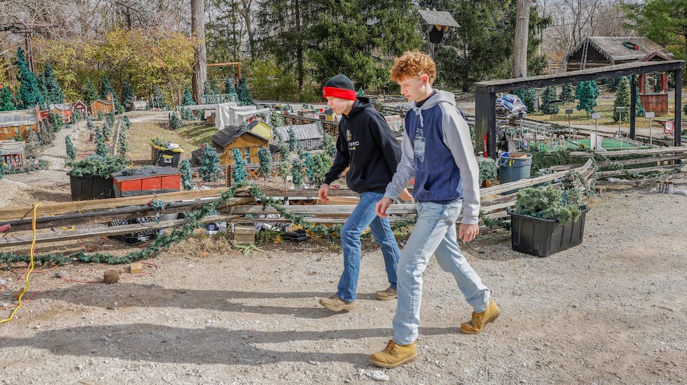 Wyatt Pyles, left, and Derek Orr walk past Christmas decorations on Monday, November 24, 2025, at Clifton Mill. JOSEPH COOKE/STAFF