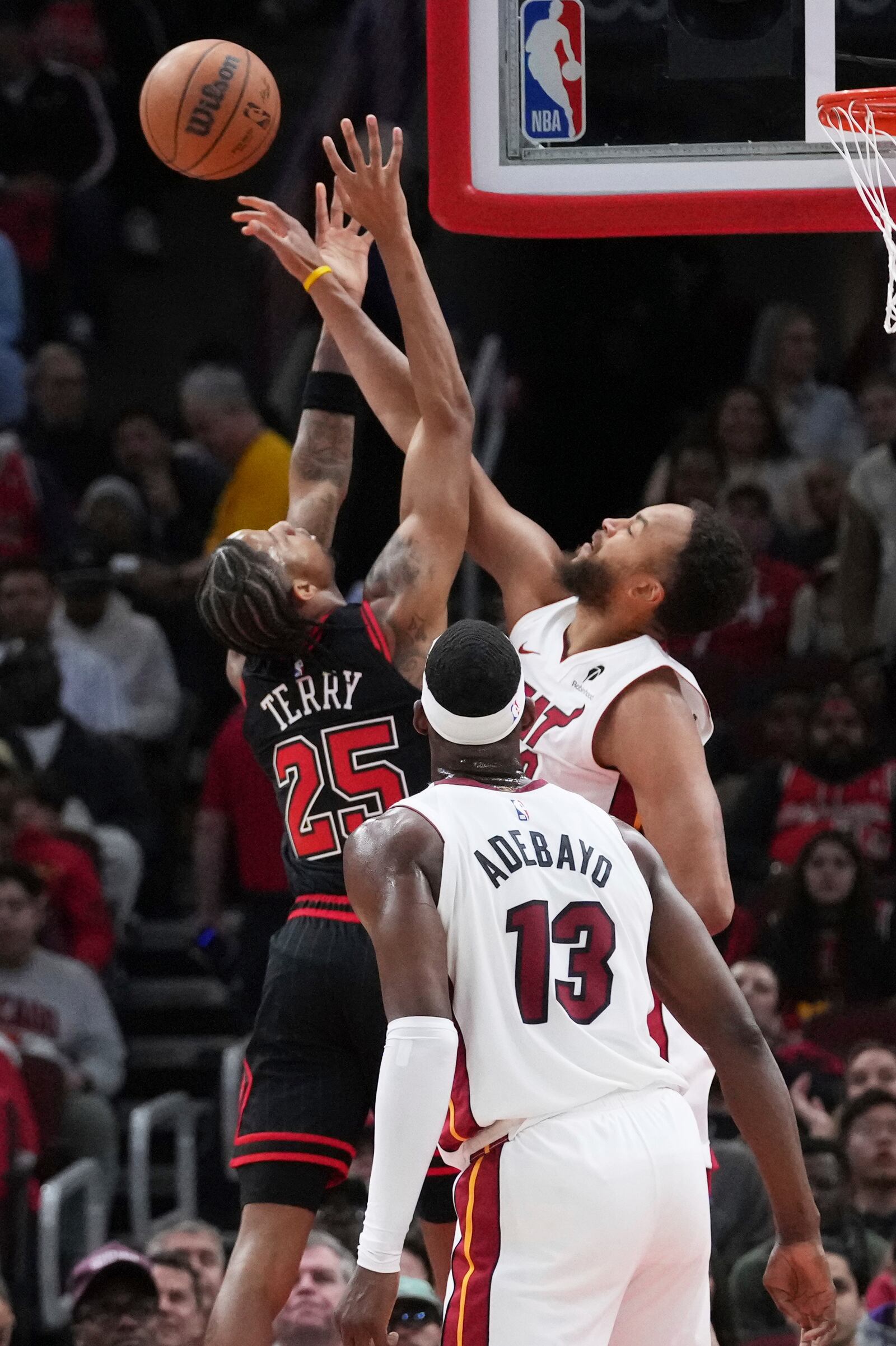 Miami Heat forward Kyle Anderson, right, blocks a shot by Chicago Bulls forward Dalen Terry during the first half of an NBA play-in tournament basketball game in Chicago, Wednesday, April 16, 2025. (AP Photo/Nam Y. Huh)