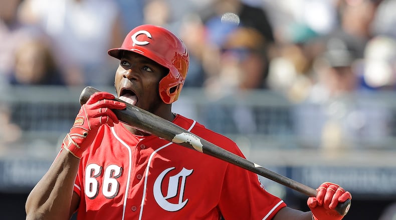 Cincinnati Reds’ Yasiel Puig licks his bat during the third inning of a spring training baseball game against the Seattle Mariners, Monday, Feb. 25, 2019, in Peoria, Ariz. (AP Photo/Darron Cummings)