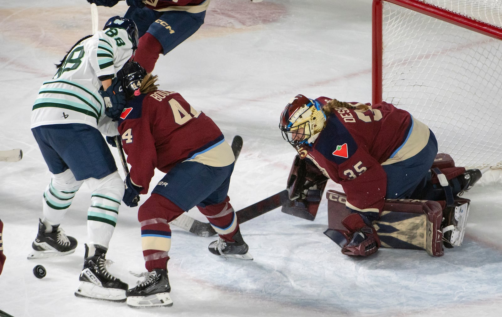 Montreal Victoire's Ann-Renee Desbiens (35) watches the puck as Boston Fleet's Lexie Adzija (88) and Victoire's Amanda Boulier (44) battle for it during first-period PWHL hockey game action in Laval, Quebec, Monday, April 28, 2025. (Peter McCabe/The Canadian Press via AP)