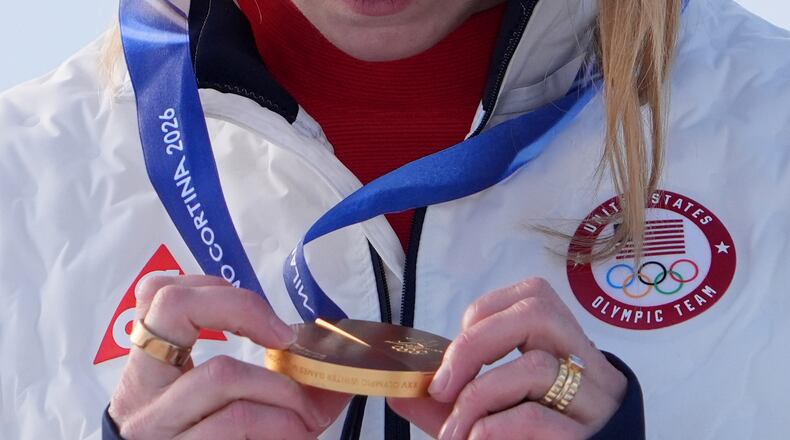 United States' Mikaela Shiffrin looks at her gold medal in an alpine ski, women's slalom race, at the 2026 Winter Olympics, in Cortina d'Ampezzo, Italy, Wednesday, Feb. 18, 2026. (AP Photo/Jacquelyn Martin)