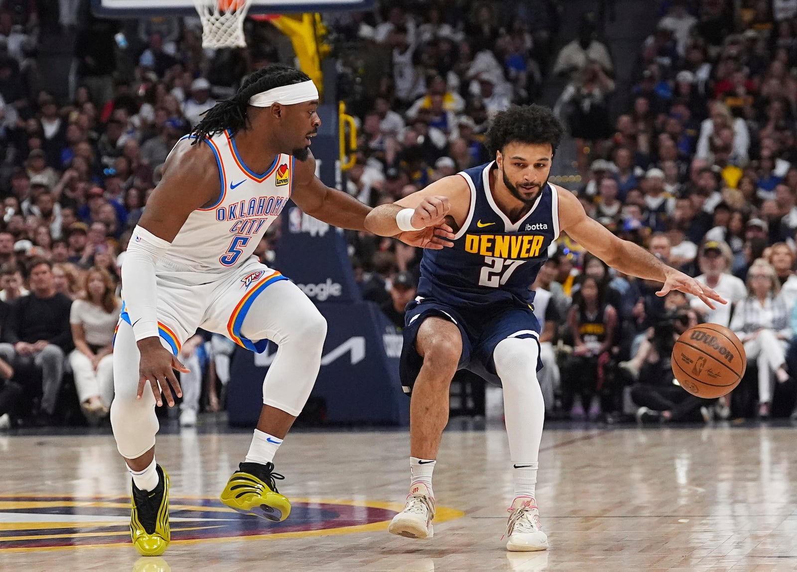 Denver Nuggets guard Jamal Murray, right, struggles to move the ball as Oklahoma City Thunder guard Luguentz Dort, left, defends in the first half of Game 4 in the Western Conference semifinals of the NBA basketball playoffs Sunday, May 11, 2025, in Denver. (AP Photo/David Zalubowski)
