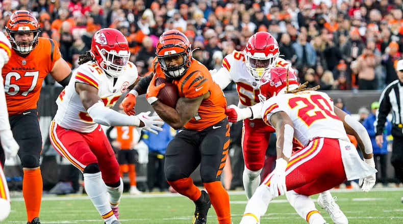 Cincinnati Bengals running back Samaje Perine (34) runs between Kansas City Chiefs linebacker Nick Bolton (32) and safety Justin Reid (20) in the first half of an NFL football game in Cincinnati, Sunday, Dec. 4, 2022. (AP Photo/Joshua Bickel)