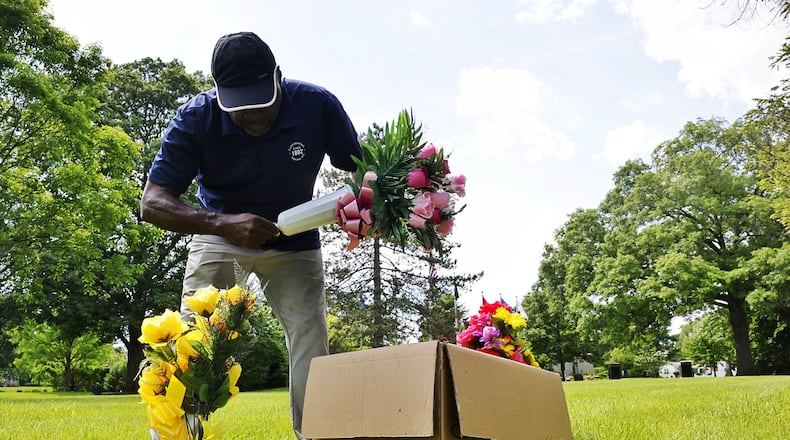Orlando Moore places flowers at the graves of his uncles who served in various branches of military ahead of Memorial Day Tuesday, May 21, 2024 st Woodside Cemetery and Arboretum in Middletown. NICK GRAHAM/STAFF
