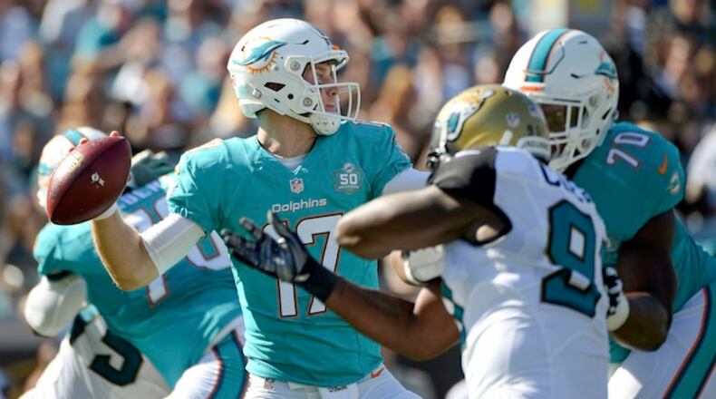 FILE - In this Sept. 20, 2015 file photo, Miami Dolphins quarterback Ryan Tannehill (17) throws a pass as he is pressured by Jacksonville Jaguars defensive end Chris Clemons left, during the first half of an NFL football game in Jacksonville, Fla. Injuries, the lack of a running game and a poor pass rush are all issues for the Dolphins as they try to rebound from a loss at Jacksonville. (AP Photo/Phelan M. Ebenhack)