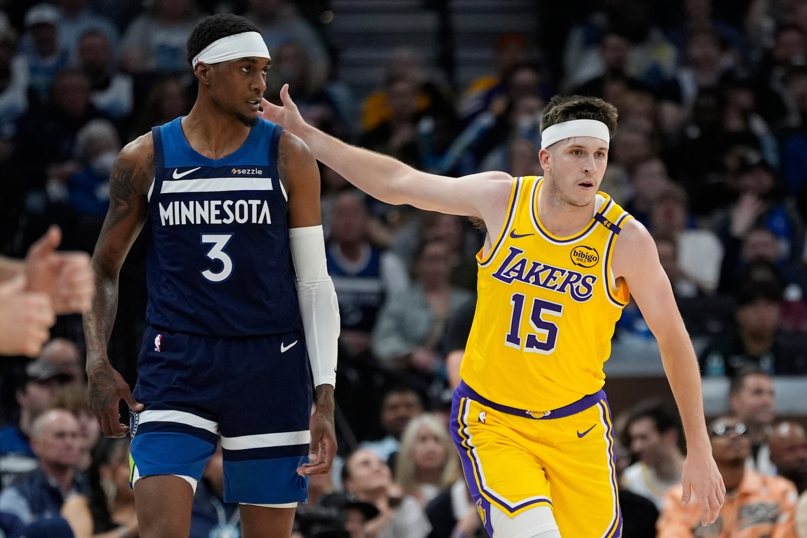 Los Angeles Lakers guard Austin Reaves (15) gestures next to Minnesota Timberwolves forward Jaden McDaniels (3) after making a 3-point basket during the first half of Game 3 of an NBA basketball first-round playoff series, Friday, April 25, 2025, in Minneapolis. (AP Photo/Abbie Parr)