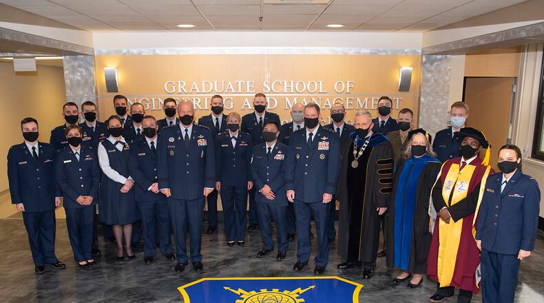 Gen. John W. “Jay” Raymond, chief of Space Operations, and Lt. Gen. James Hecker, Air University commander and president, pose with Air Force Institute of Technology distinguished graduates prior to their graduation ceremony March 25. U.S. AIR FORCE PHOTO/R.J. ORIEZ