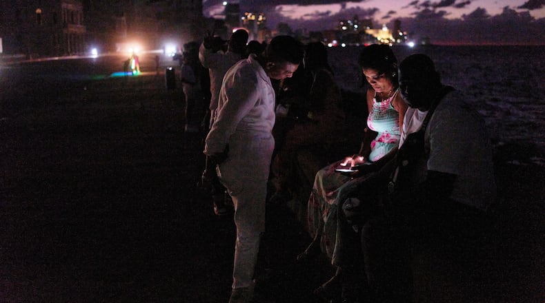 People spend the night in the dark on the Malecon during a blackout in Havana, Cuba, Saturday, March 21, 2026. (AP Photo/Ramon Espinosa)