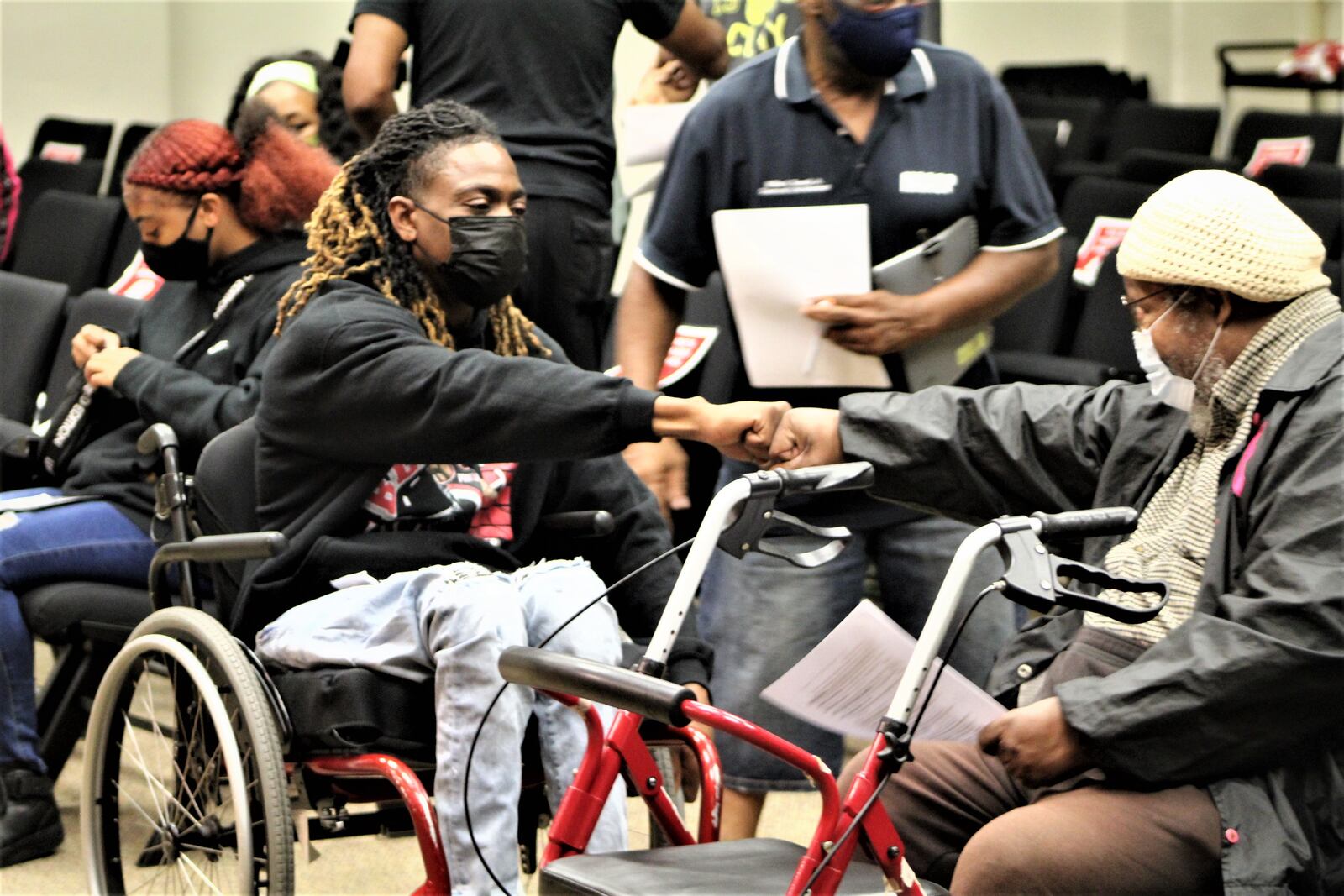 Clifford Owensby bumps fists with Bishop Richard Cox before a Dayton City Commission meeting. Cox and others called on the city to suspend and fire the officers who pulled Owensby from his vehicle during a traffic stop. CORNELIUS FROLIK / STAFF