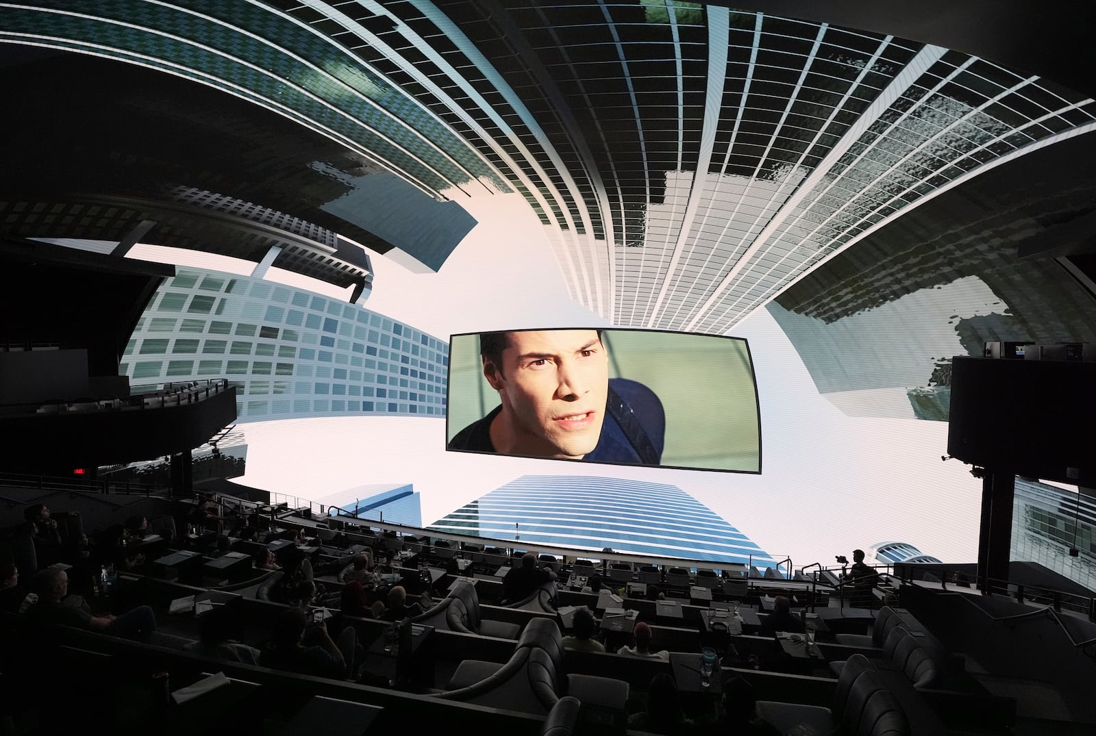 A scene from the film "The Matrix" is surrounded by immersive urban visuals during a screening of "The Matrix in Shared Reality" on Wednesday, May 28, 2025, at Cosm Los Angeles in Inglewood, Calif. (AP Photo/Chris Pizzello)