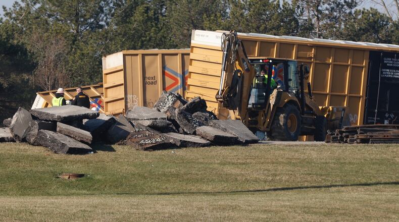 Train company workers clean up Sunday, March 5, 2023 after a train derailment Saturday afternoon at Ohio Route 41 near the Clark County Fairgrounds. BILL LACKEY/STAFF