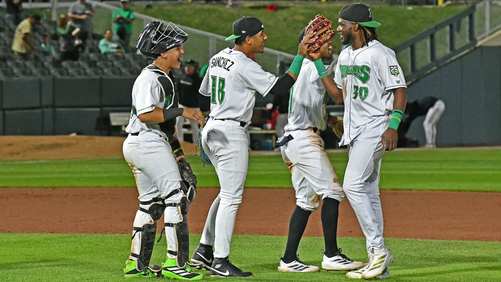 Yerlin Confidan, who singled in the winning run, is greeted by Carlos Sanchez and catcher Diego Omana after catching the final out Tuesday night at Day Air Ballpark. JEFF GILBERT/CONTRIBUTED