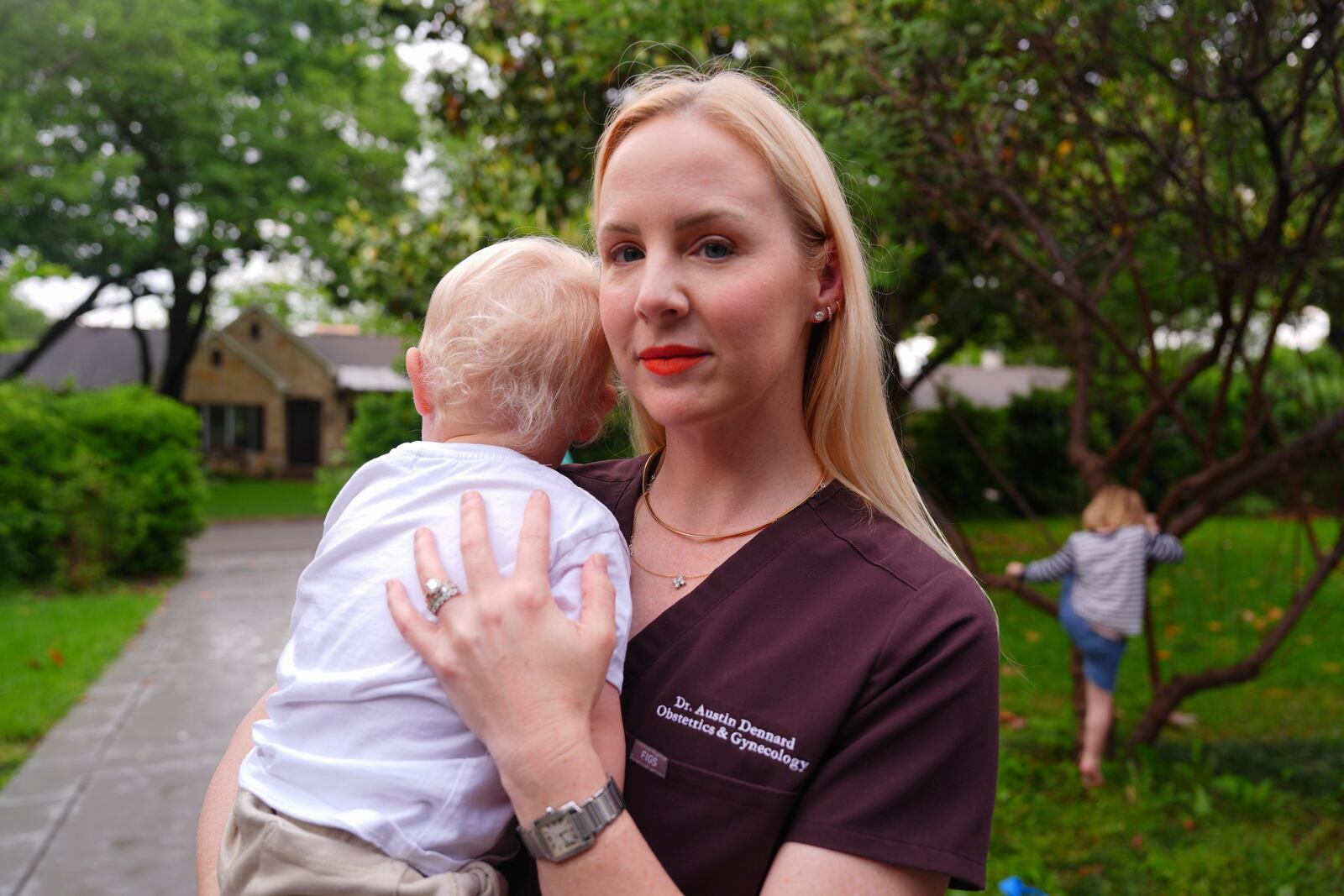 Dr. Austin Dennard holds her son as she poses for a portrait at her home in Dallas, Friday, May 2, 2025. (AP Photo/LM Otero)