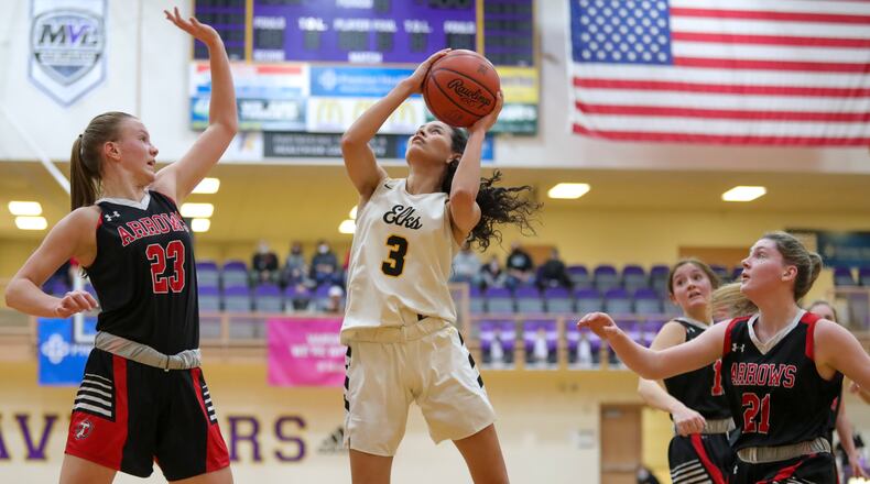 Cutline: Centerville High School senior Amy Velasco shoots the ball in front of Tecumseh's Gabrielle Russell (left) and Terah Harness (right) during their game on Monday night at the Vandalia Butler Student Activities Center. The Elks won 71-40. Michael Cooper/CONTRIBUTED