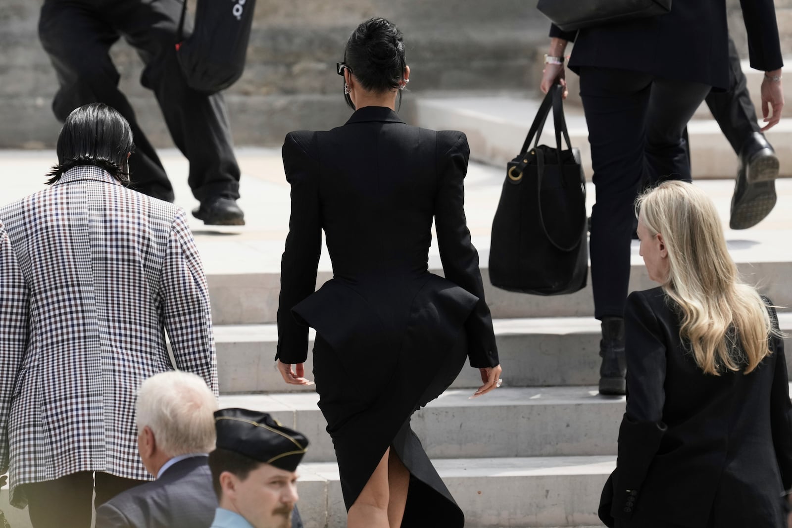 Kim Kardashian, center, walks up the steps of the palace of justice as she arrives to testify regarding a robbery of millions of dollars in jewels from her Paris hotel room in 2016, in Paris, Tuesday, May 13, 2025. (AP Photo/Aurelien Morissard)