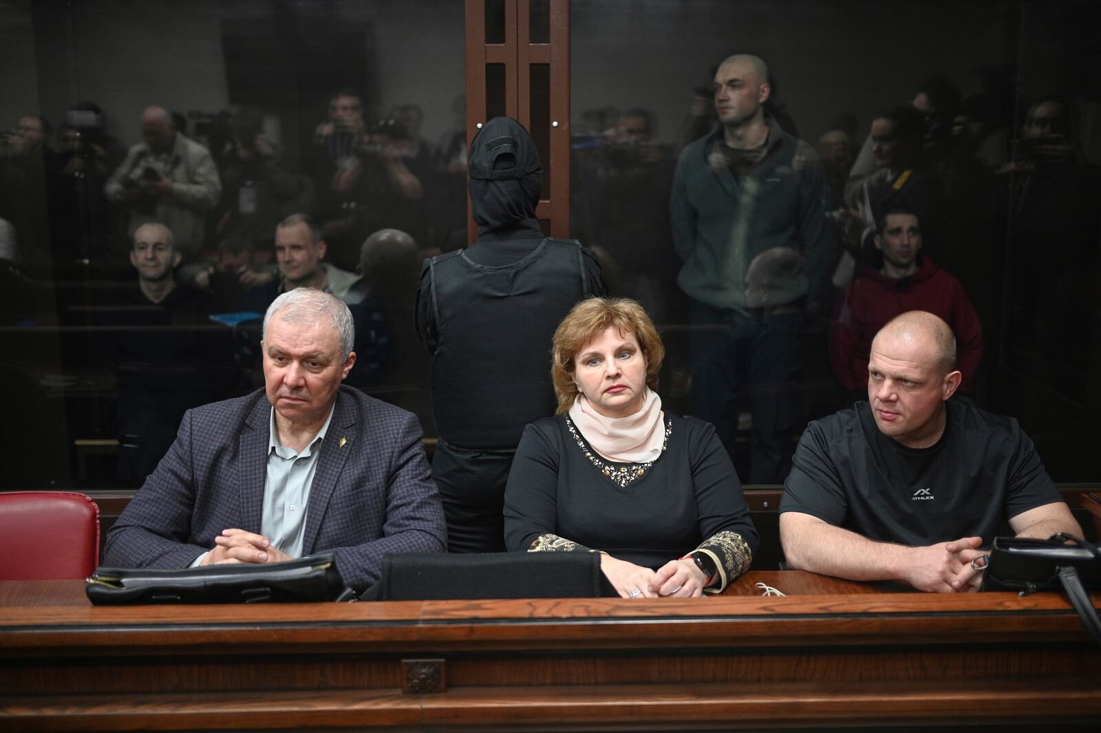 Lawyers of Ukrainians captured by Russia during hostilities in Ukraine sit in front of the defendant's cage during a hearing at the Southern District Military Court in Rostov-on-Don, Russia, Wednesday, March 26, 2025. (AP Photo)