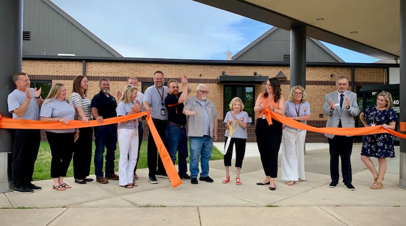 Teachers and administrators of Beavercreek City Schools, alongside contractors from Synergy and Mills Development and city officials cut the ribbon on new preschool facilities for the growing district, August 12, 2025. LONDON BISHOP/STAFF