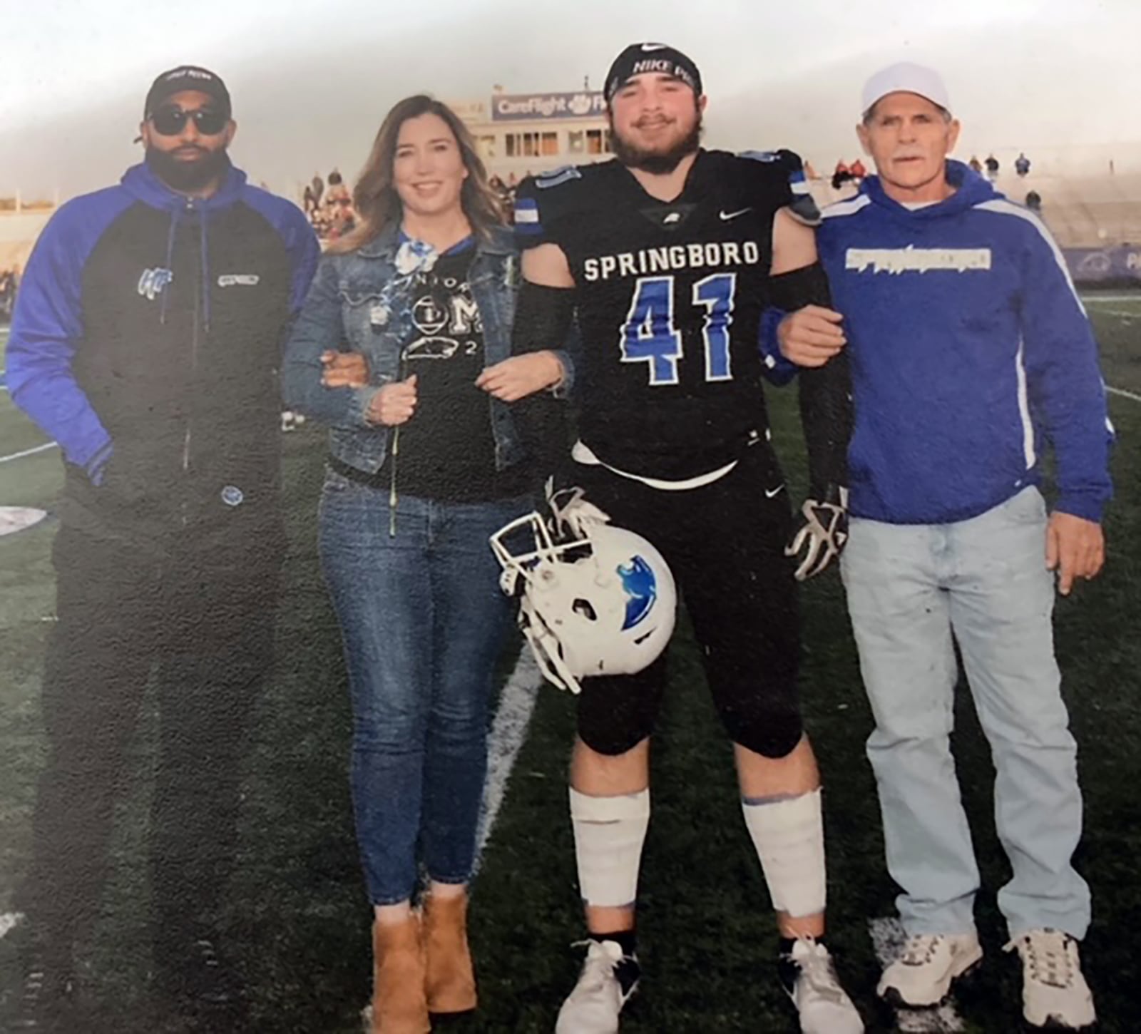 Tracy Rice (second from left) is seen with her son Elliott Rice (left), younger son Peyton Gatliff and Peyton's grandfather Kevin Gatliff at a Springboro High School football game. CONTRIBUTED

