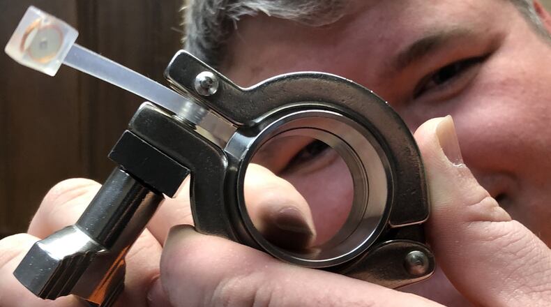 David Newman peers through a fitting joined by one of his company’s high-tech gaskets. STAFF/LAWRENCE BUDD