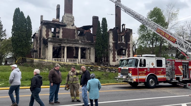 Dayton Fire Department staff, city of Dayton officials and representatives of Preservation Dayton discuss the Traxler Mansion fire at the corner of Broadway and Yale in West Dayton on Sunday, April 23, 2023. JEREMY P. KELLEY / STAFF