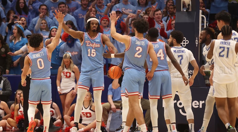 Dayton players slap hands with DaRon Holmes II after a defensive stop against Saint Louis on Tuesday, Jan. 16, 2024, at UD Arena. David Jablonski/Staff