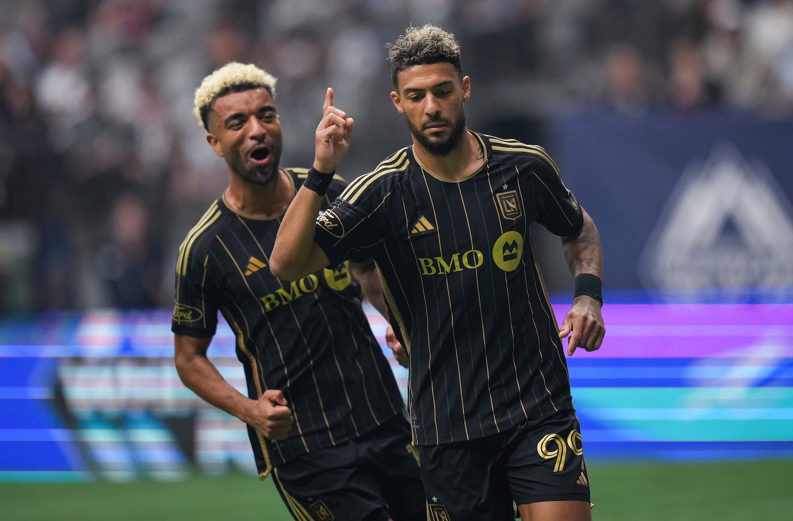 Los Angeles FC's Denis Bouanga, right, and Timothy Tillman, left, celebrate after Bouanga's penalty kick goal against the Vancouver Whitecaps during the first half of an MLS soccer match in Vancouver, British Columbia, Sunday, May 11, 2025. (Darryl Dyck/The Canadian Press via AP)