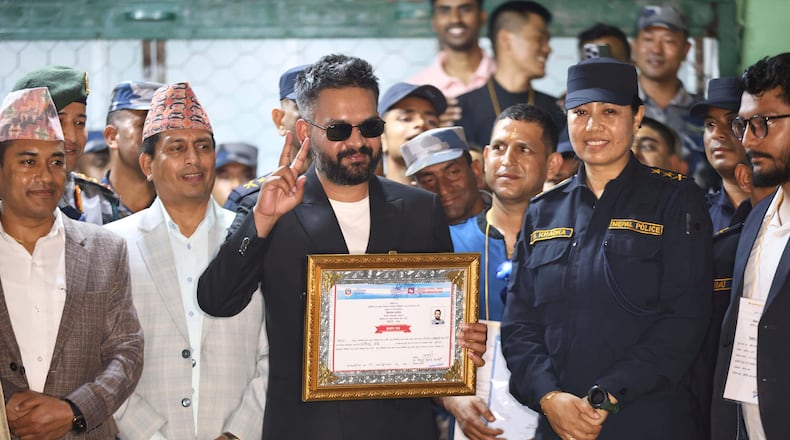 Balendra Shah, foreground, former mayor of Kathmandu Metropolitan City and prime ministerial candidate of the Rastriya Swatantra Party, receives his victory certificate after defeating former Prime Minister Khadga Prasad Oli of the Communist Party of Nepal–Unified Marxist-Leninist (CPN-UML) in Jhapa, about 267 miles (430 kilometers) southeast of Kathmandu, Nepal, Sunday, March 8, 2026. (AP Photo/Umesh Karki)
